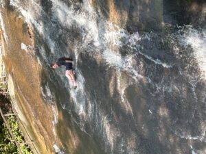 a 4-H'er sliding down Sliding Rock, a natural waterslide